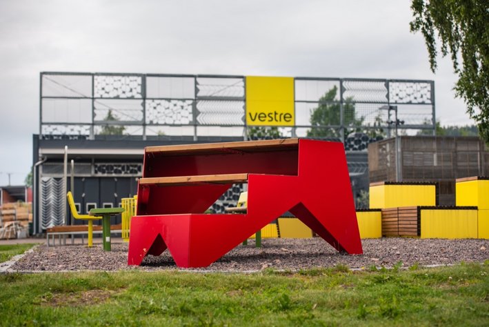 Rotes, 3-stufiges STOOP-Möbel der Firma Vestre im Freien auf Kiesgrund