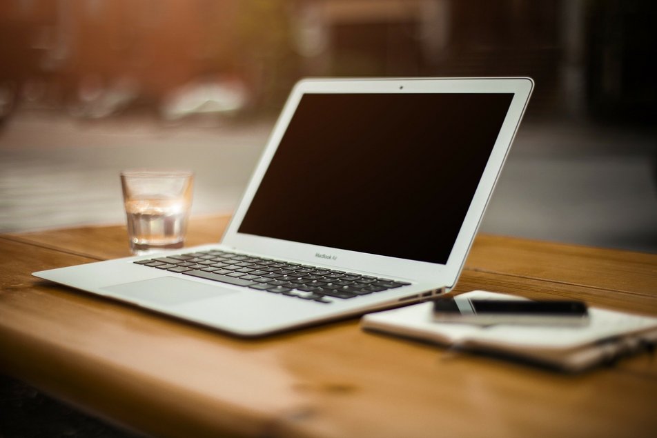 Laptop und Schreibutensilien auf Tisch