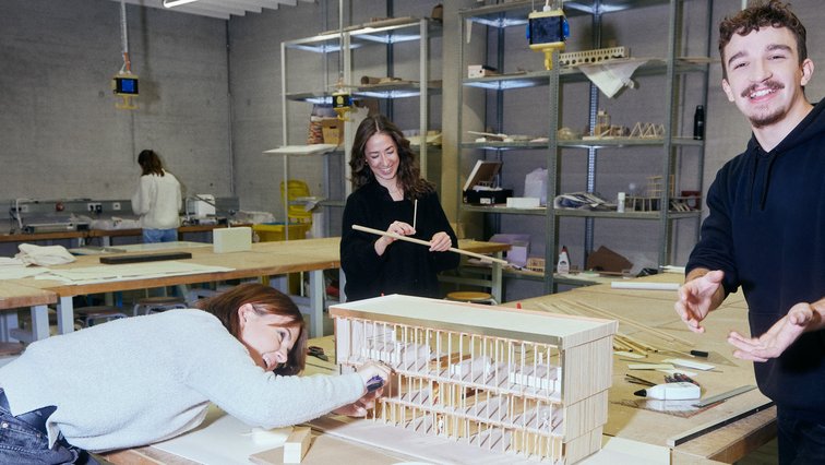 Drei Studierende bauen an einem Architektur-Modell