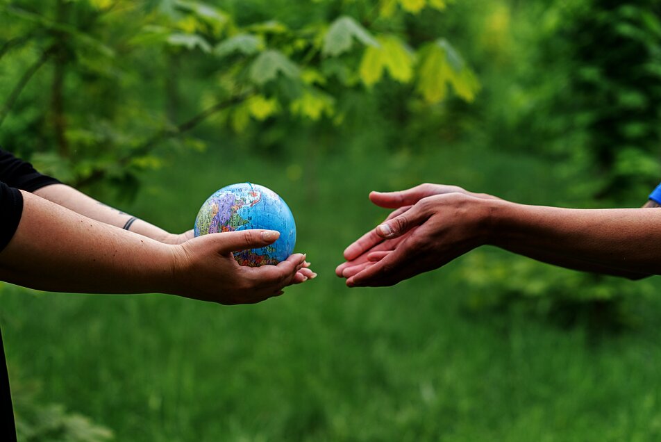 Weltkugel geht als Ball von Hand zu Hand.