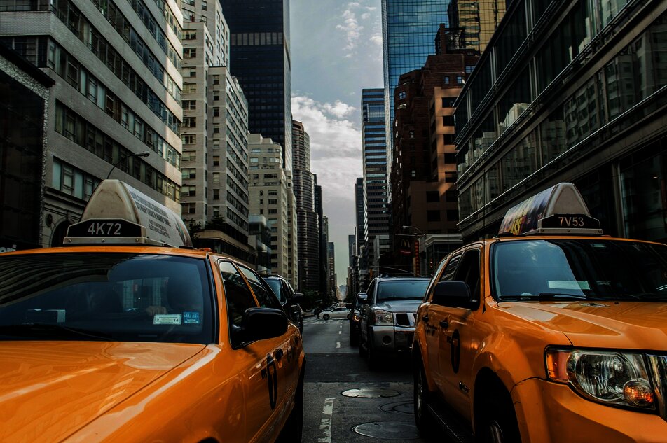 Frontansicht von Taxis in einer Straße mit Hochhäusern im Hintergrund