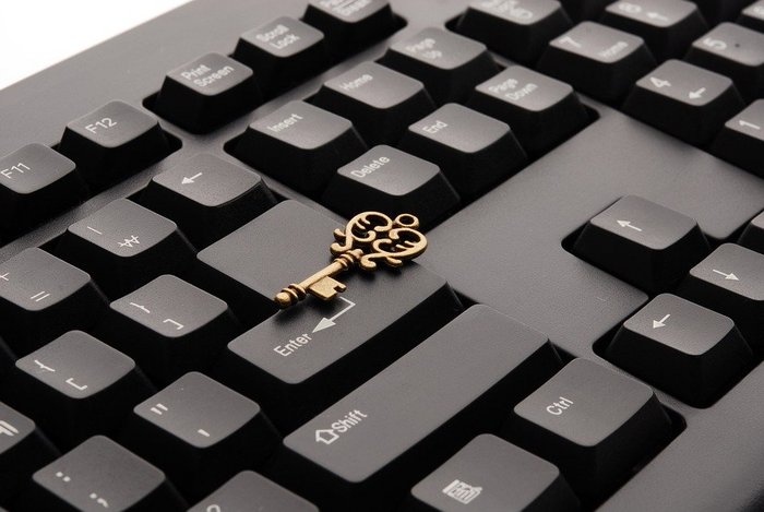 Makroaufnahme einer Tastatur mit einem darauf liegenden Messingschlüssel