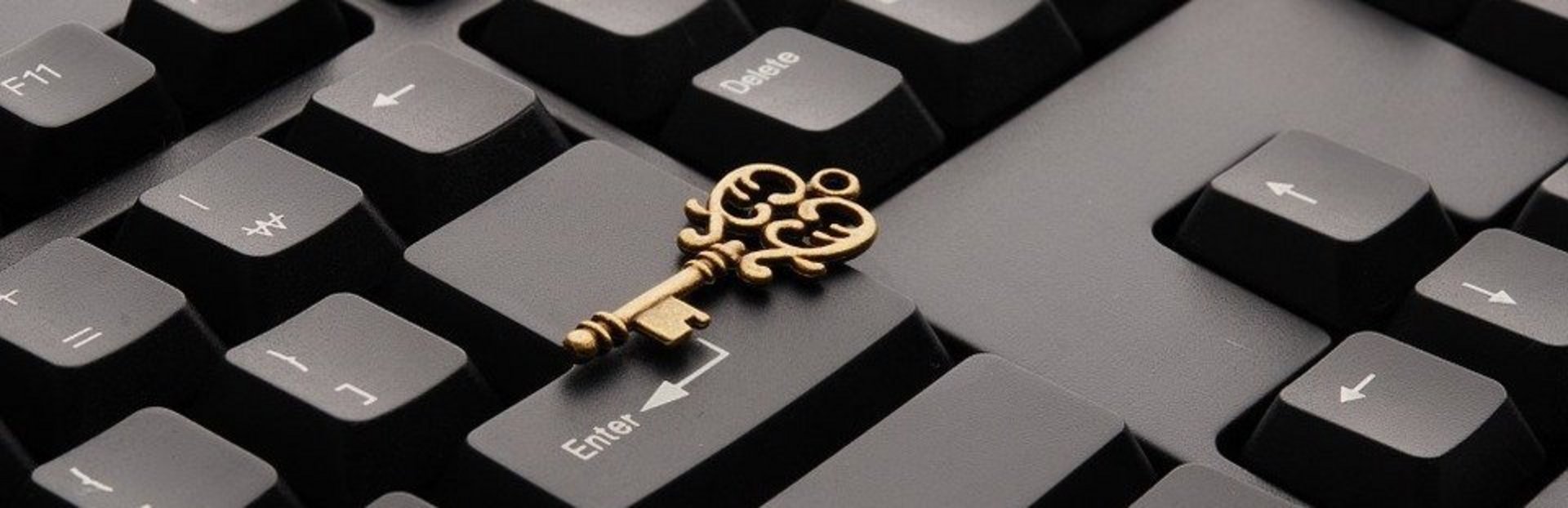Makroaufnahme einer Tastatur mit einem darauf liegenden Messingschlüssel