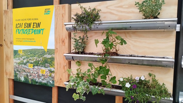 Begrüntes Wandelement am Block 4 und Plakat der Kampagne Jetztklimachen