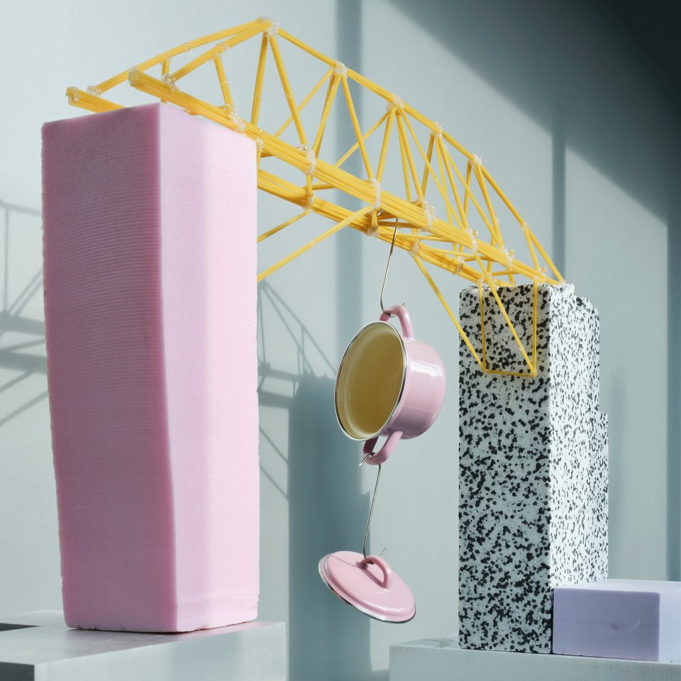 Darstellung einer Brücke aus Spaghetti, an der ein Topf hängt