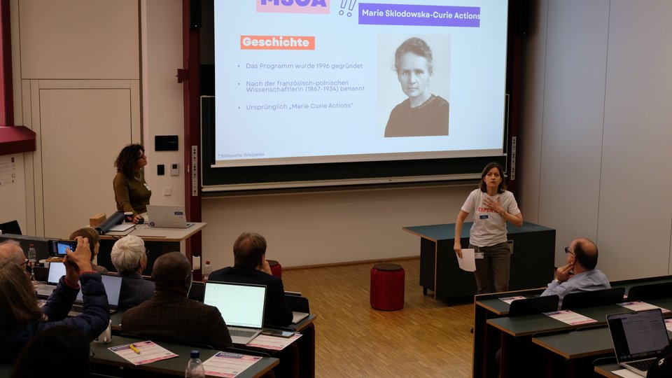 Die Referentin stellt eine Folie vor "MSCA: Marie Sklodowska-Curie Actions"