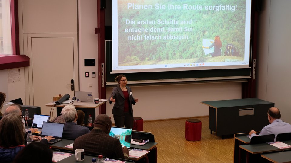 Referentin stellt Folie vor "Planen Sie Ihre Route sorgfältig"