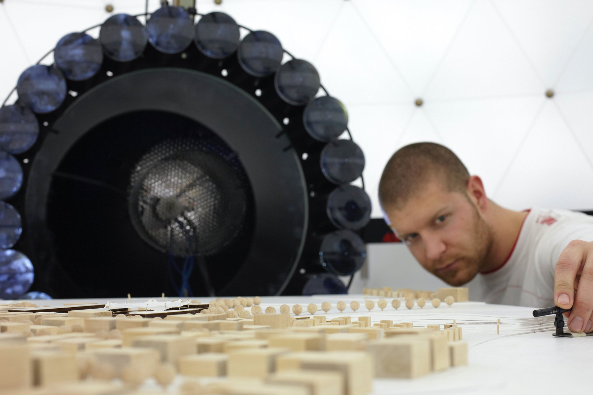 Mann schaut sich Architekturmodell an 