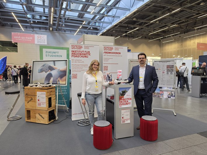 Messestand mit Zsanet Süli, akademische Mitarbeiterin im Studiengang  „Augmented Reality/Virtual Reality-Engineering" und Prof. Dr. rer. nat. Michael Krone, Professor für Augmented Reality/Virtual Reality Engineering