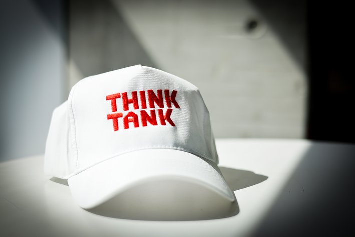 Eine weiße Cap mit rotem Stick "Thinktank" in der HFT Schrift