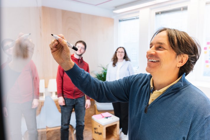 Professor schreibt auf Whiteboard