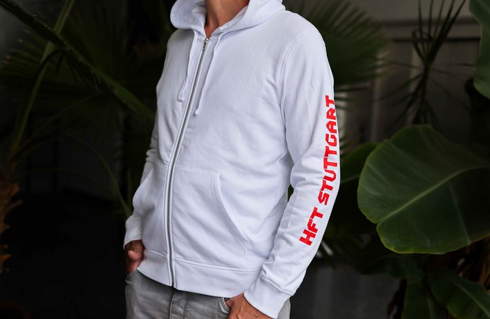 Weiße Zipper Kapuzen-Jacke mit der Aufschrift "HFT Stuttgart" am linken Ärmel