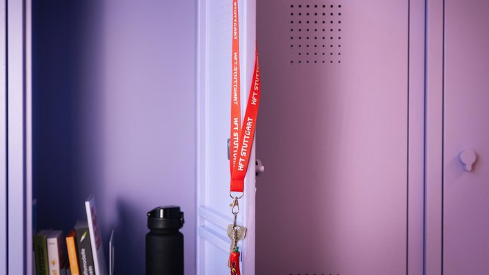 Roter Lanyard mit Schlüssel hängt an einem Metallschrank