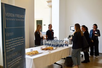 Besucher stehen am Buffet im Rahmen der Veranstaltung Tag der Lehre 2024