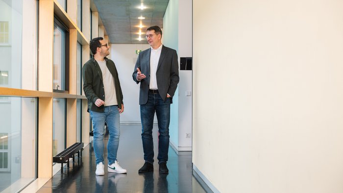 Zwei Mitarbeiter unterhalten sich im Gang