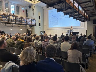 Ein Redner am Pult auf dem Bauphysikertreffen 2025