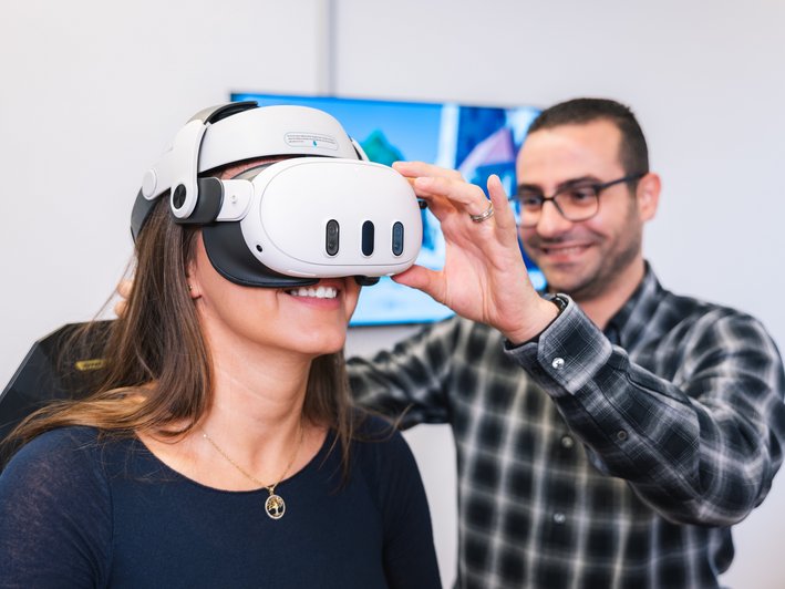 Mitarbeiter nimmt Probandin die VR-Brille ab