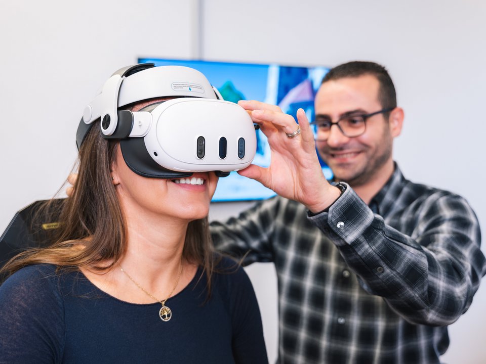 Mitarbeiter nimmt Probandin die VR-Brille ab