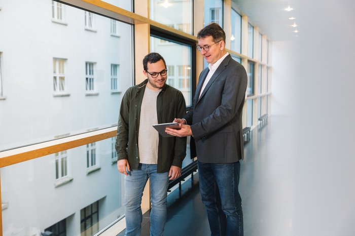 Zwei Mitarbeitende in Gang mit Tablet