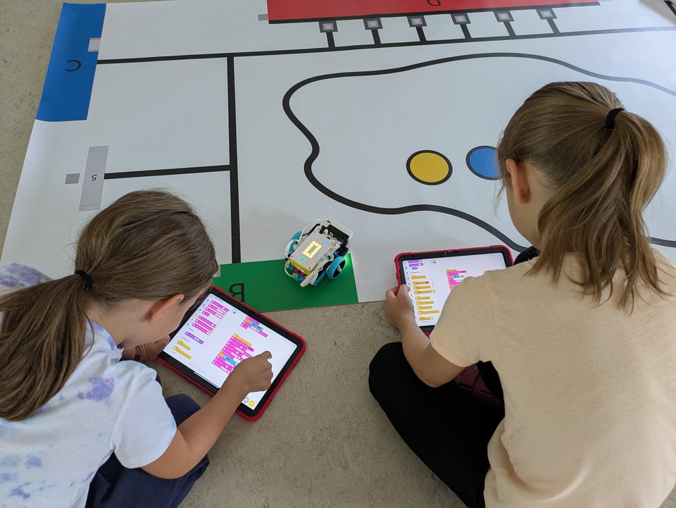 Schülerinnen beim Programmieren mit einem Tablet