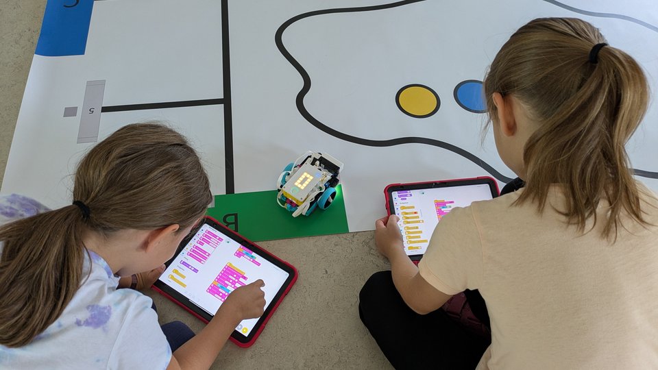 Schülerinnen beim Programmieren mit einem Tablet