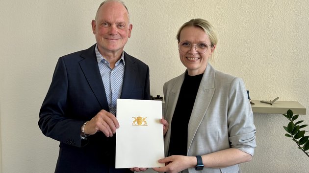 Brigitte Heintz-Cuscianne erhält die Urkunde von Ministerialdirektor Dr. Hans J. Reiter.