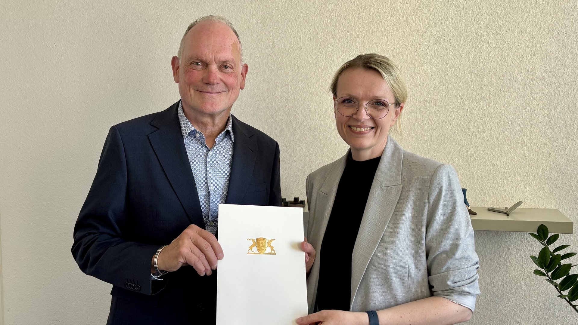 Brigitte Heintz-Cuscianne erhält die Urkunde von Ministerialdirektor Dr. Hans J. Reiter.