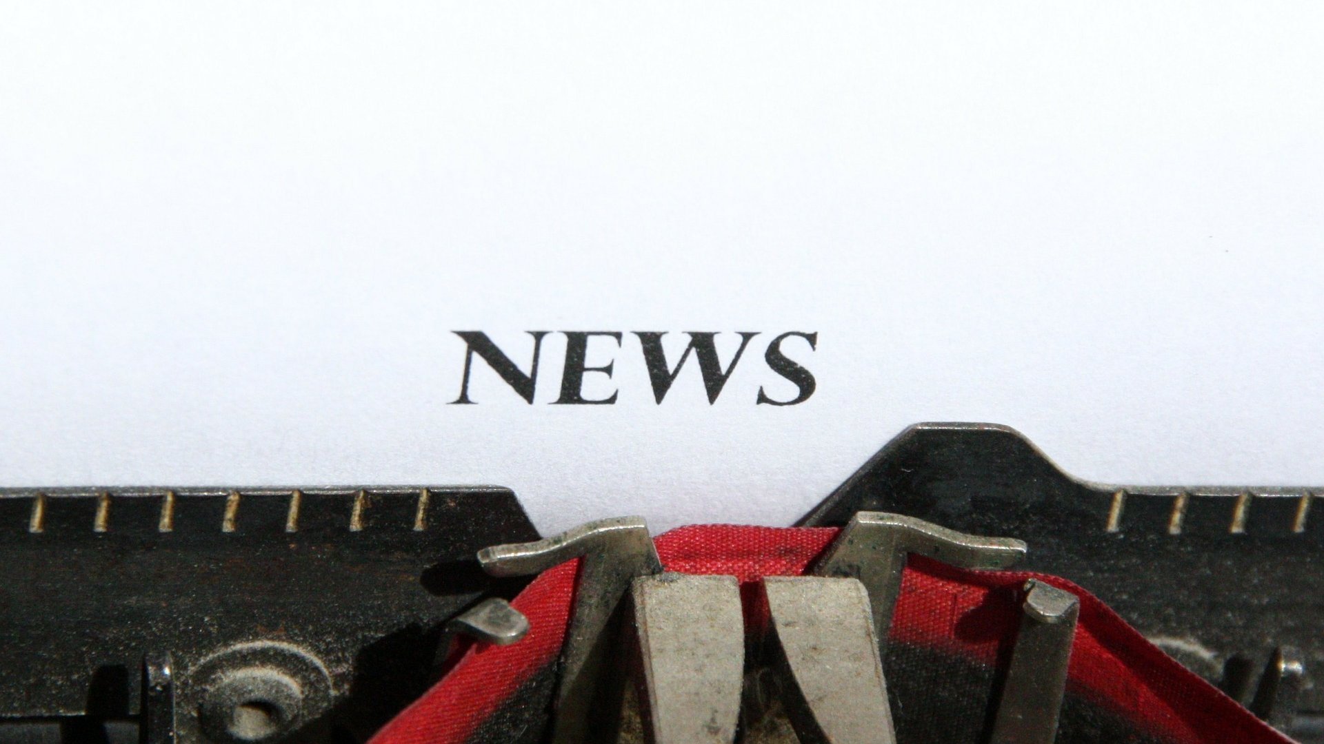 Das Wort News auf einem Blatt Papier abgebildet