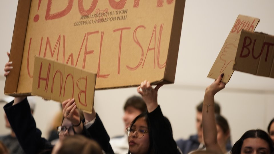 Student:innen beim Klimaplanspiel 2025 halten ein Schild hoch