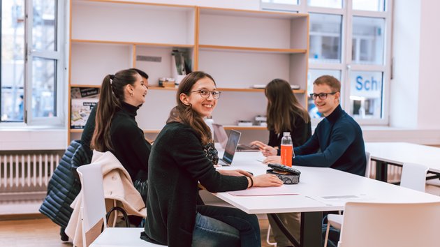 Studierende sitzen am Tisch und lernen.