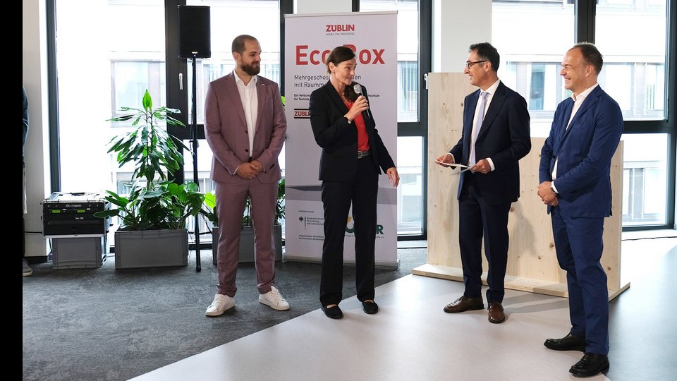 Katja Rade am Mikrofon, Cem Özdemir neben ihr sowie zwei weitere männliche Personen