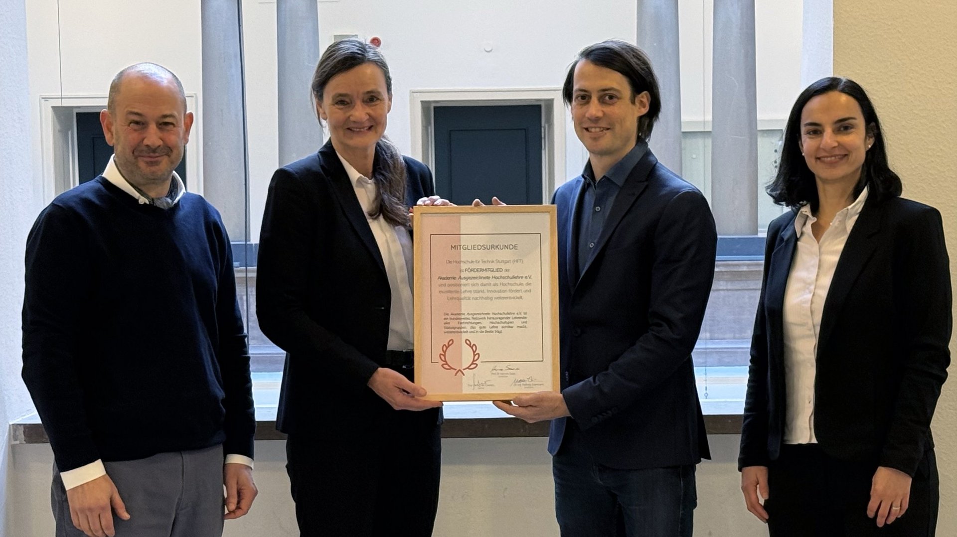 Dr. Matthias Eisenmann, Mitglied des Vorstands der Akademie Ausgezeichnete Hochschullehre e. V., überreicht HFT-Rektorin Prof. Dr. Katja Rade die Fördermitgliedschaft. Rechts im Bild: Prof. Dr. Melanie Baur, Gewinnerin des Landeslehrpreises Baden-Württemberg 2025 und neues Mitglied in der Akademie sowie Prof. Dr.-Ing. Jan Cremers, Dekan der Fakultät Architektur und Gestaltung, der sich im Vorstand der Akademie als Beisitzer engagiert.