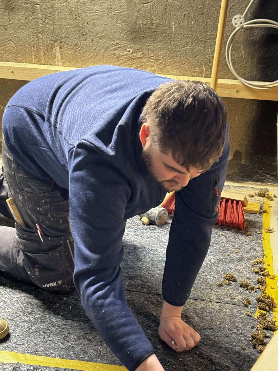 Student misst auf dem Boden im Raum der Stille etwas aus.