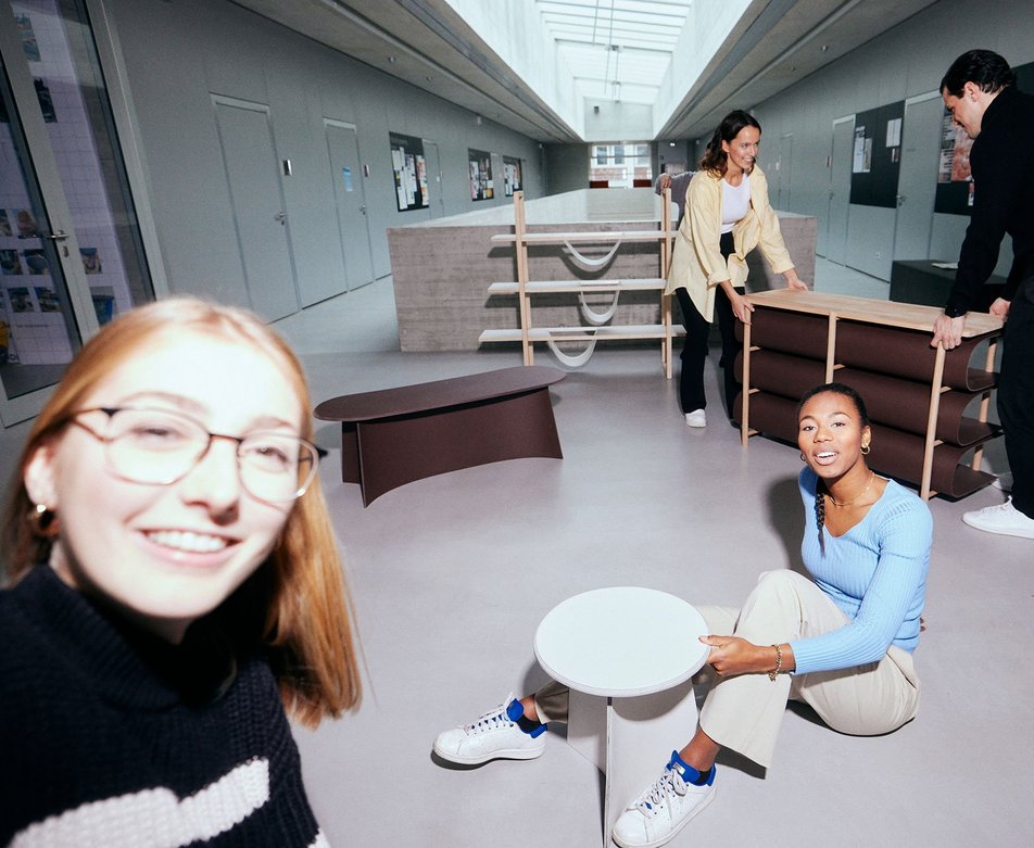Selfie einer Studentin aus dem Studiengang Innenarchitektur die sich und Komillitoninnen beim Aufbau einer Ausstellung fotografiert.