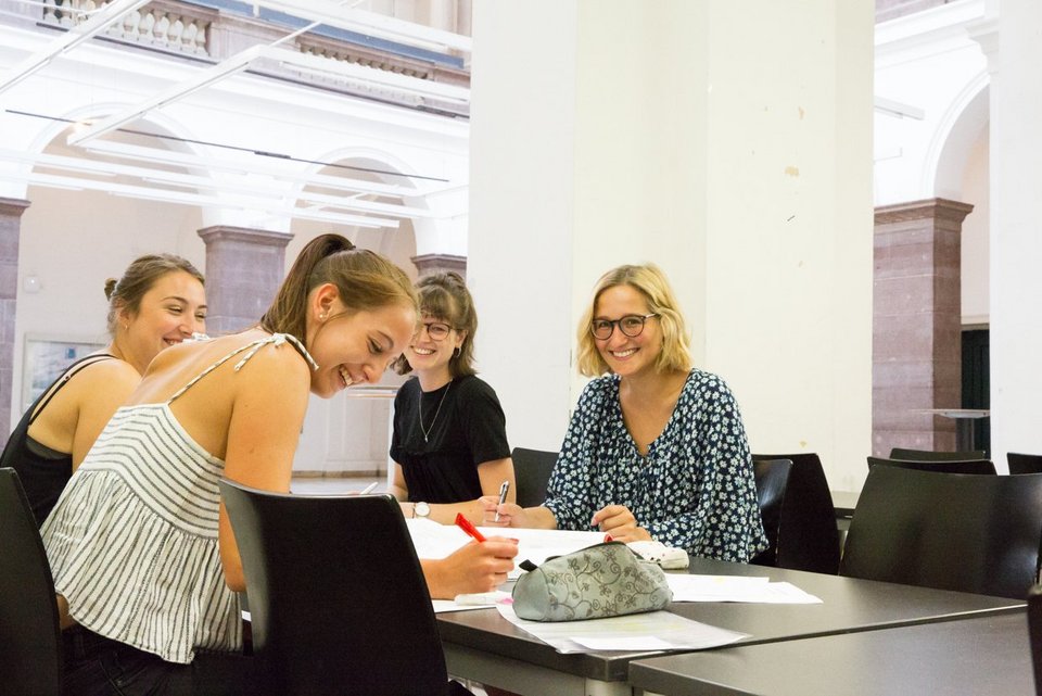 Vier Studierende sitzen am Tisch zusammen