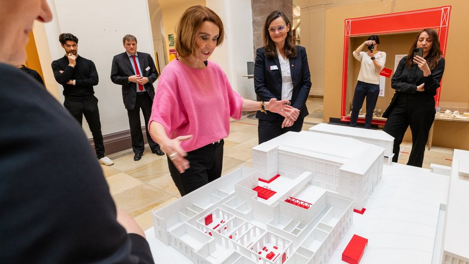 Petra Olschowski bestaunt ein Architekturmodell.