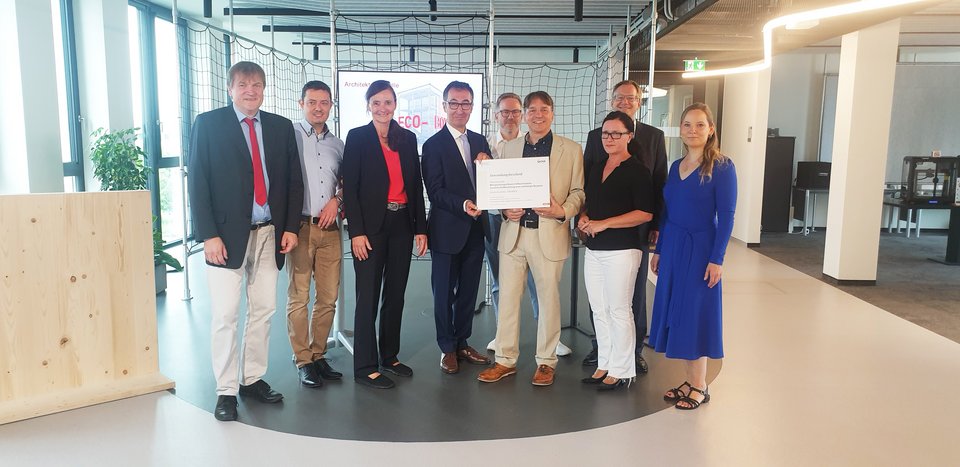 Eine Gruppe von Personen, in der Mitte Cem Özdemir und Prof. Dr. Bernt Zeitler, die den Zuwendungsbescheid halten.