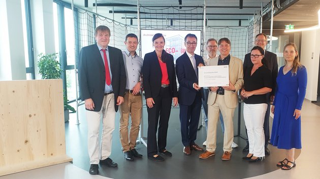 Eine Gruppe von Personen, in der Mitte Cem Özdemir und Prof. Dr. Bernt Zeitler, die den Zuwendungsbescheid halten.