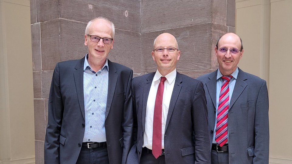 Neu gewählter Dekan und zwei Prodekane (zwei Männer) der Fakultät C